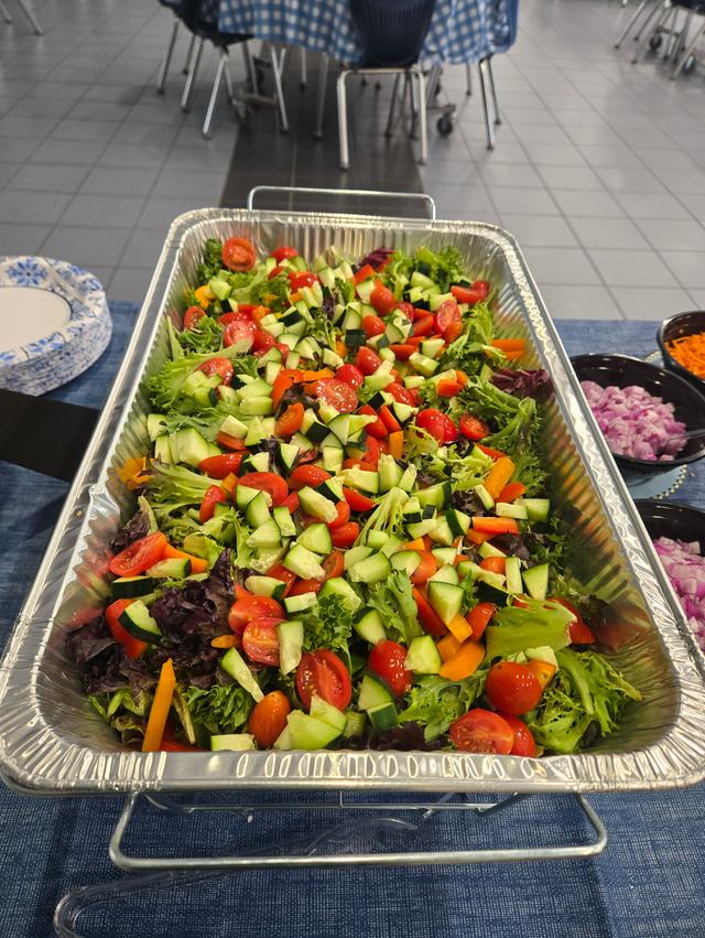 A full pan of fresh garden salad set out on a buffet